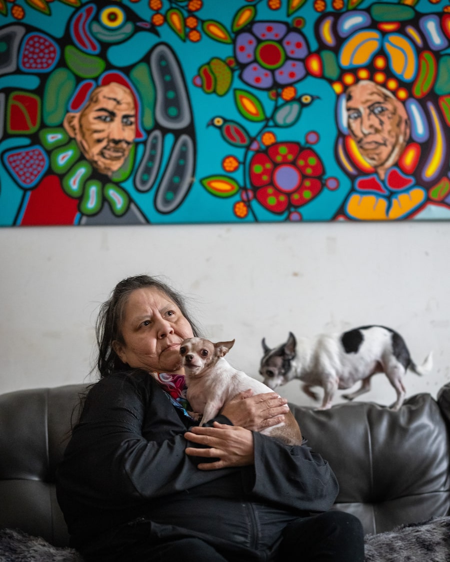 Lisa Morrisseau at her home in Keewaywin First Nation. A painting by her brother Eugene is on the wall behind her.