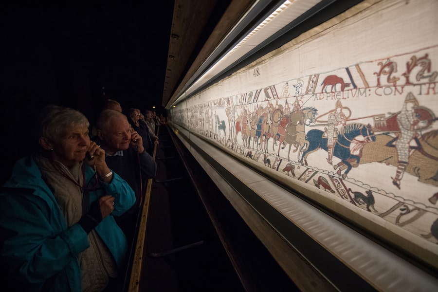 Museum visitors look at the Bayeux Tapestry, which illustrates Britain's conquest by William the Conqueror in 1066, in Bayeux, western France, in September, 2019.