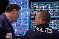 Trader Terrance McCauley, left, and specialist Anthony Matesic confer on the floor of the New York Stock Exchange, Monday, April 20.