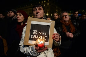 A woman holds a poster reading 'Je suis Charlie' during a vigil in front of the French embassy in January, 2015, in Berlin.