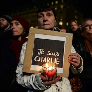 A woman holds a poster reading 'Je suis Charlie' during a vigil in front of the French embassy in January, 2015, in Berlin.