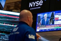 A trader works on the floor, as a screen displays U.S. President Donald Trump during a press briefing at the White House following the Supreme Court's ruling on tariffs, at the New York Stock Exchange (NYSE) in New York City, U.S., February 20, 2026.  REUTERS/Brendan McDermid