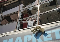 A resident removes pieces of glass from broken windows in a shopping mall hit by a Russian air strike, amid Russia's attack on Ukraine, in Sumy, Ukraine, August 6, 2026. REUTERS/Stringer