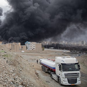 Plumes of smoke rise over oil depot tanks hit by joint Israel-U.S. strikes overnight near Tehran.