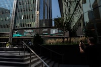 A person takes a photo of the TMX Market Centre in Toronto, Wednesday, Sept. 11, 2024. 
