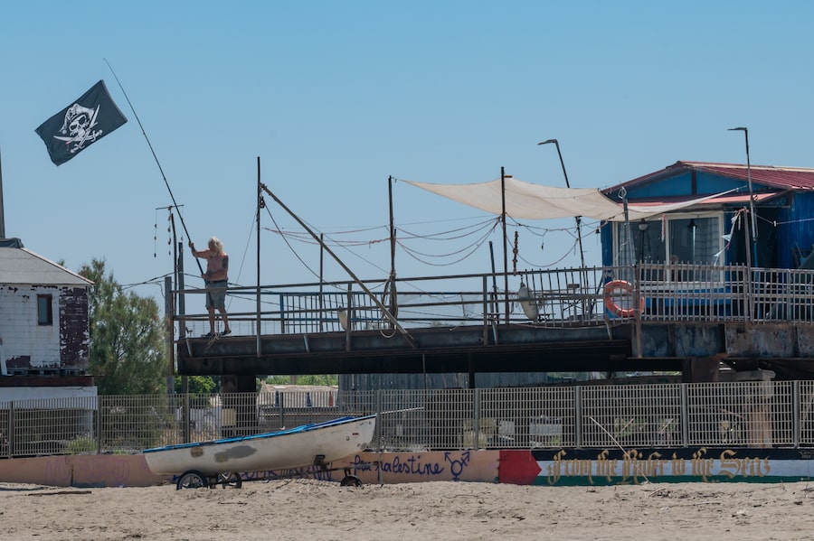 Gianfranco Miconi stands on the terrace of his traditional fishing hut in Isola Sacra, the place he has called home for decades and is determined to remain.