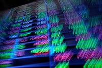 A board above the trading floor of the New York Stock Exchange with stock symbols is shown in this image, Tuesday, July 1, 2025. (AP Photo/Richard Drew)