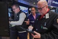 Specialist Glenn Carell, left, and Dilip Patel, center, work with trader Jeffrey Vazquez on the floor of the New York Stock Exchange, Friday, June 26, 2026. (AP Photo/Richard Drew)