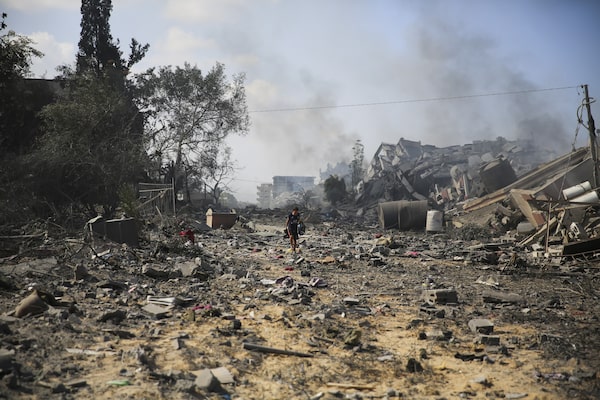A Palestinians boy walks by the the rubble of buildings destroyed in the Israeli bombardment on al-Zahra, on the outskirts of Gaza City, Friday, Oct. 20, 2023.