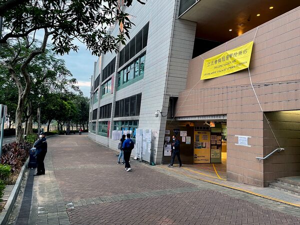 People walk past a largely empty polling station in Tiu Keng Leng, a neighbourhood in Hong Kong's New Territories, during legislative elections on Sunday, December 19, 2021.