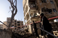 Men look at residential buildings damaged by an Iranian missile strike in Arad, southern Israel, on Sunday.